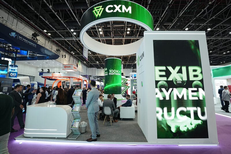 Estande de exposição da CXM exibindo infraestrutura de pagamento e trading